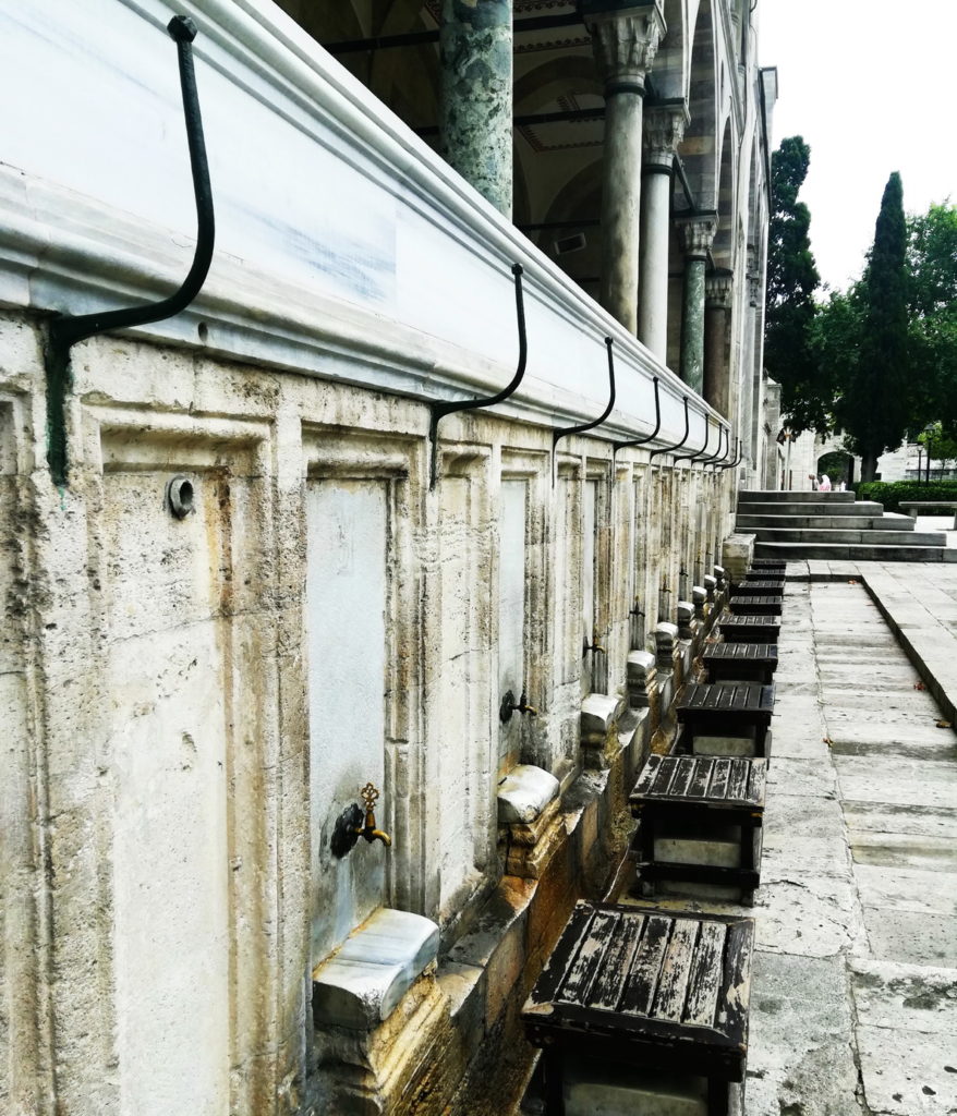 There are many places to wash one's feet to prepare for prayer. The hooks above each place are for resting tall hats.