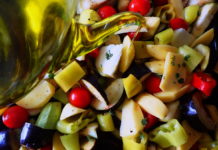 Briam - tourlou, vegetables and fresh herbs, drizzled with olive oil and ready for the oven