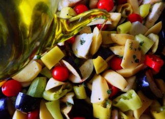 Briam - tourlou, vegetables and fresh herbs, drizzled with olive oil and ready for the oven