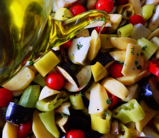 Briam - tourlou, vegetables and fresh herbs, drizzled with olive oil and ready for the oven