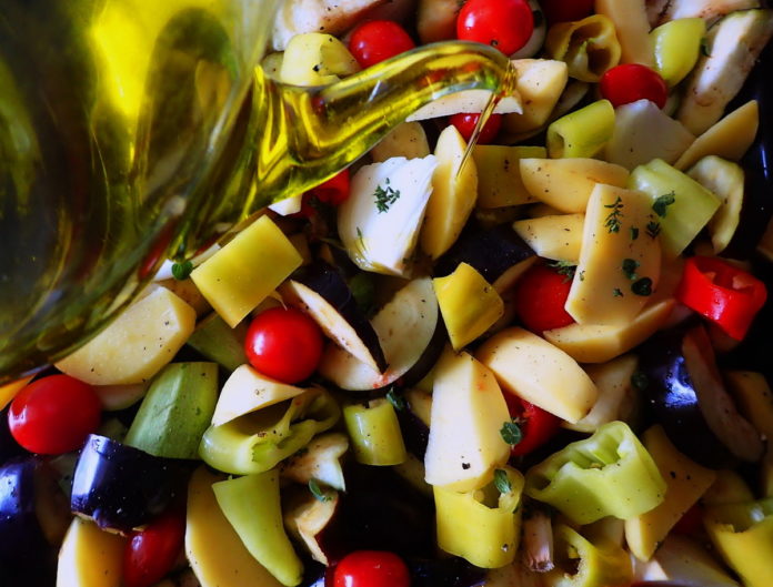 Briam - tourlou, vegetables and fresh herbs, drizzled with olive oil and ready for the oven