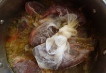 Fresh fish in cheesecloth simmers in apot of Greek fish soup - psarosoupa