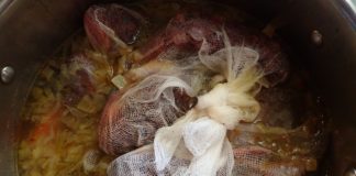 Fresh fish in cheesecloth simmers in apot of Greek fish soup - psarosoupa