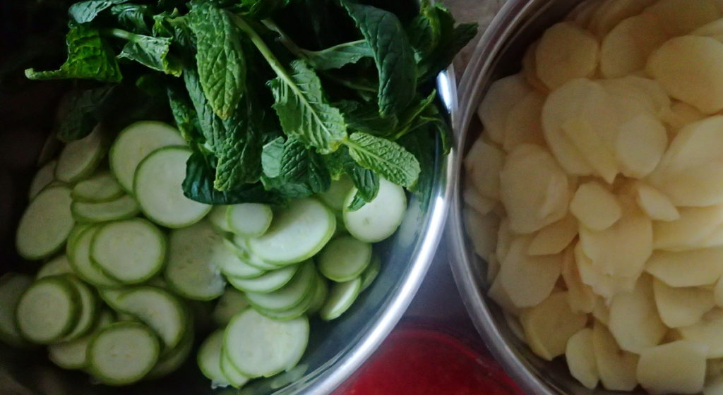 Thin slices of zucchini and potato, grated tomato, and fresh mint for assembling the boureki
