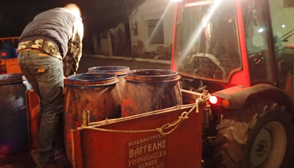 Vats of pomace for tsipouro arriving by tractor